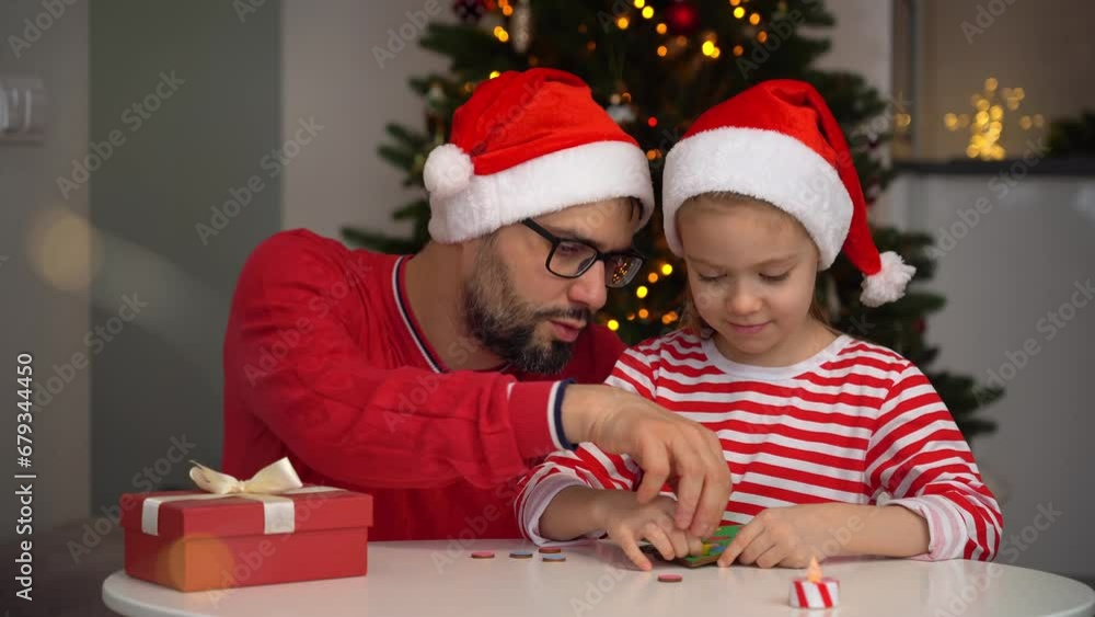 Father and little daughter collect wooden puzzle in form of Christmas tree at home and laugh. Happy family fun play board New Year game. Leisure for holidays with child Father and little daughter collect wooden puzzle in form of Christmas tree at home and laugh. Happy family fun play board New Year game. Leisure for holidays with child