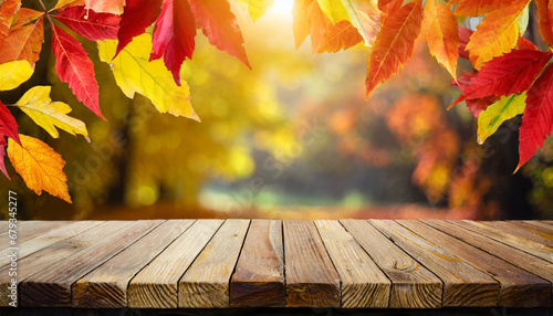 wooden table and blurred autumn background autumn concept with red yellow leaves background