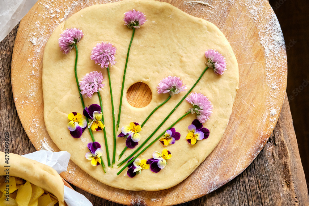 pie decorated with blooming chives and violets. Top view, wooden background. pie decorated with blooming chives and violets. Top view, wooden background.