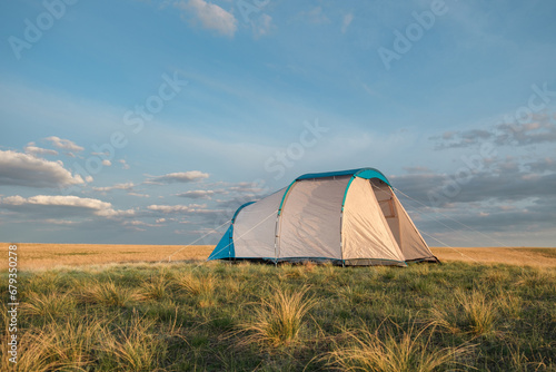 Tent in the steppe against the backdrop of the sunset