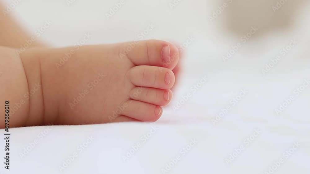 baby's small feet on a white bed, a place for text, a close-up of a little baby's feet baby's small feet on a white bed, a place for text, a close-up of a little baby's feet