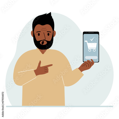 A man holds a mobile phone in his hand with an application for online shopping. The phone has a shopping cart.