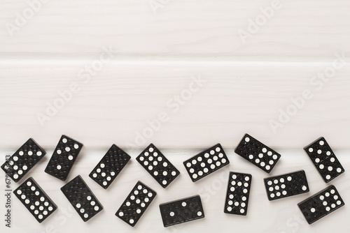 Black domino tiles on wooden background, top view