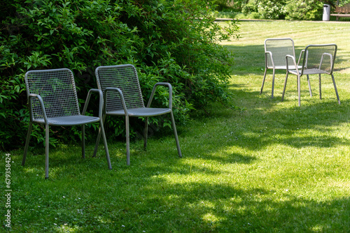 Metal chairs in spring garden. Metal garden furniture for picnics and birdwatching