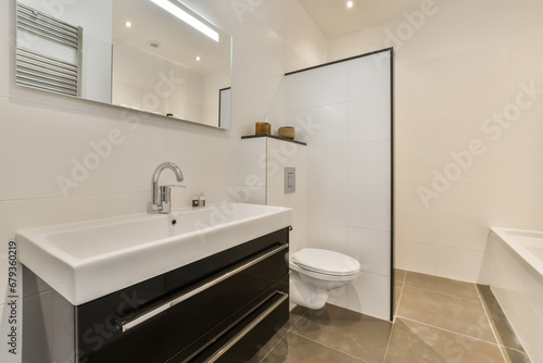 a modern bathroom with black and white fixtures on the wall  sink and toilet in the photo is taken from above