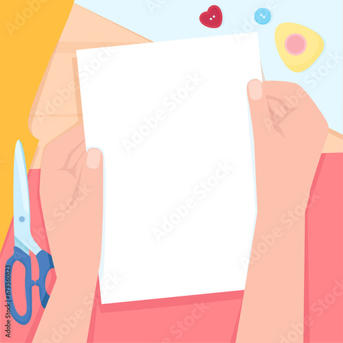 Female hands with a white piece of paper on the background of a table with sewing tools