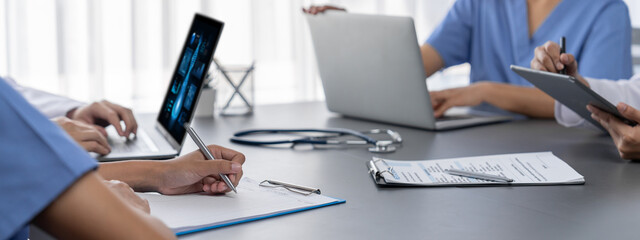 Doctor and nurse in medical meeting discussing strategic medical treatment plan together with report and laptop. Medical school workshop training concept in panoramic banner. Neoteric