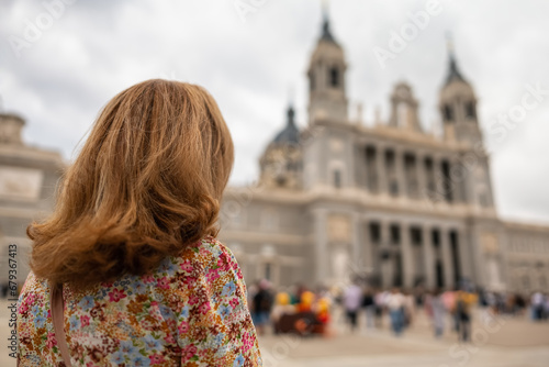 Tourist woman looking at the imposing facade of the Almudena Cathedral in Madrid. © josemiguelsangar
