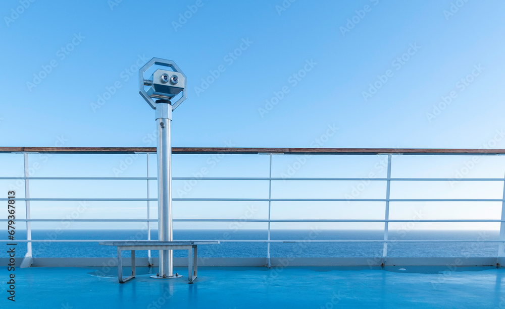Obraz premium Jumelles sur le pont d'un navire de croisière en navigation en mer avec un ciel bleu sans nuage.