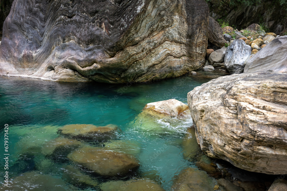 Water flows through a sculptural gorge, where the swirls of ancient rock formations meet the dynamic play of light on the turquoise water's surface. Water flows through a sculptural gorge, where the swirls of ancient rock formations meet the dynamic play of light on the turquoise water's surface.