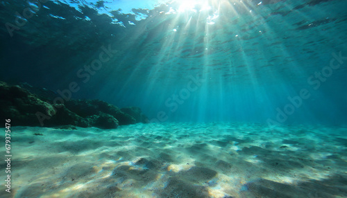 underwater background deep blue sea and beautiful light rays with sandy floor photo