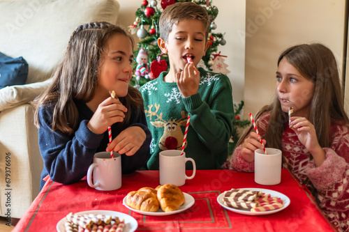 Family Breakfast. Excited Kids in Christmas Attire with Cocoa and Cookies