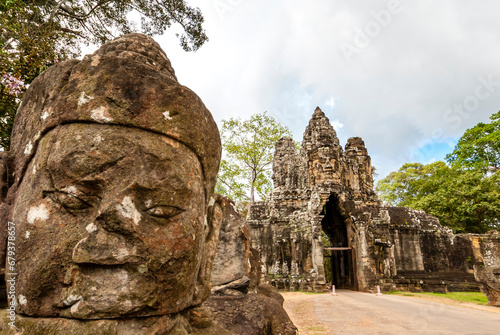 South gate of Angkor Thom along with a bridge of statues of gods and demons. Two rows of figures each carry the body of seven-headed naga. Angkor, Siem Reap province, Cambodia, Asia photo