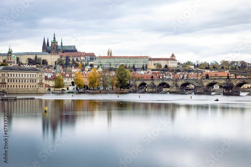 Picturesque scene featuring a tranquil body of water with a bridge spanning its width in Prague © Wirestock