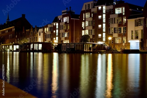 Scenic view of the river and city buildings illuminated at night. Leiden, the Netherlands