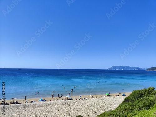 Group of people having fun in the crystal-clear waters of the ocean at a picturesque sandy beach