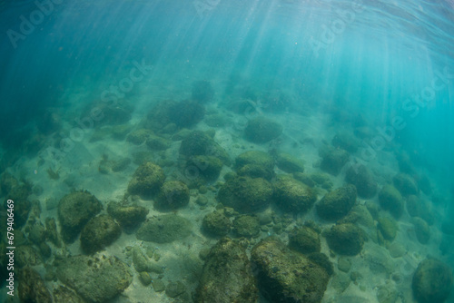 Rock and sand view underwater.