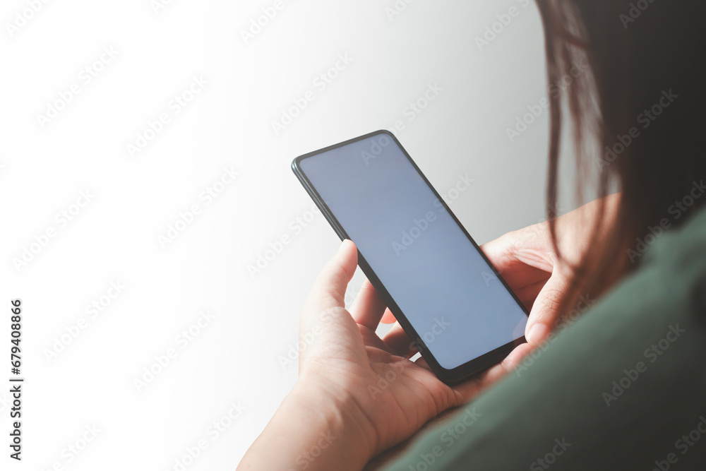 Close up of beautiful Asian woman hand holding smartphone mockup of blank screen, shot from rear view. Isolated on white background. Close up of beautiful Asian woman hand holding smartphone mockup of blank screen, shot from rear view. Isolated on white background.