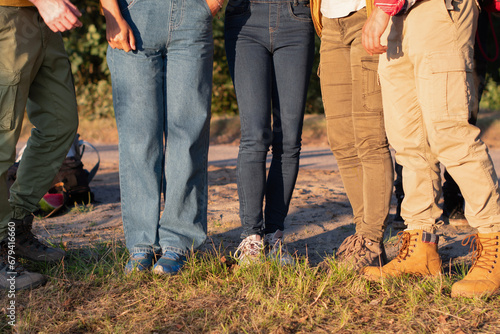 group of people wearing sturdy shoes and thick trousers to protect against ticks and mosquitoes, Only legs and tracking boots are visible, High quality photo photo