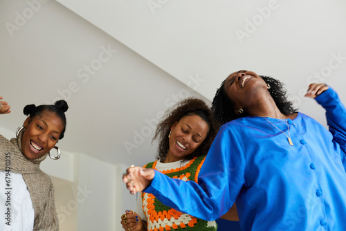 Group of three black women dancing together and laughing. Concept of diverse, stylish, fashion, beauty and jewelry 