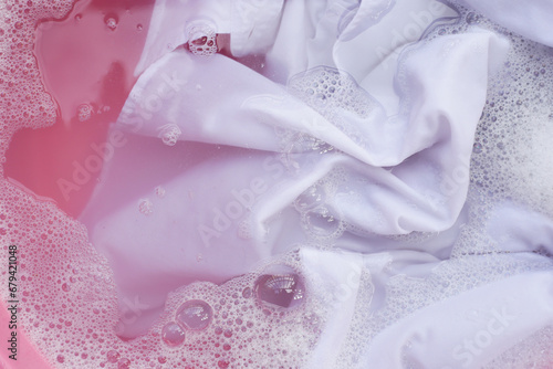 Fototapeta Naklejka Na Ścianę i Meble -  Laundry concept, white shirt soaking in water with detergent water dissolution, washing cloth