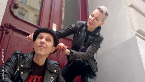 Adult couple preparing to shooting. Sense of togetherness and affection, reflecting the bond between the two individuals. People are clad in leather biker jackets, embodying the punk style.  photo