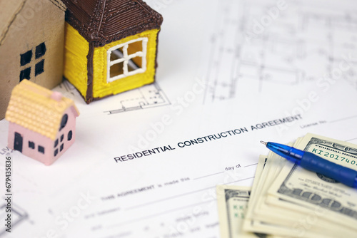 Residential construction agreement ready to sign with small toy houses and pen. Construction contract. Permission to build