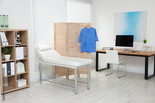 Modern medical office with doctor's workplace and examination table in clinic © New Africa
