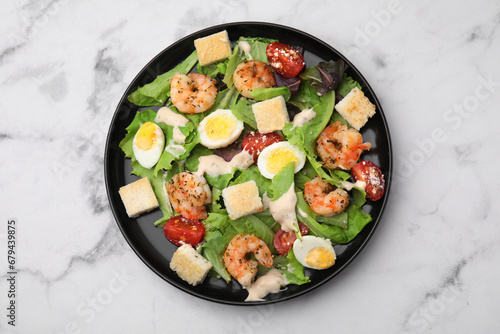 Delicious Caesar salad with shrimps on white marble table, top view
