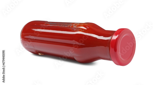 Glass bottle of tasty ketchup isolated on white