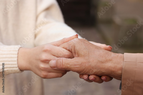 Trust and support. People joining hands outdoors, closeup