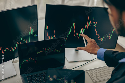 Fotografie Forex traders Man in front of multiple computer monitors Automated computer monitor of business processes from financial stock analysis data graphs