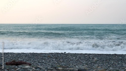 Waves crash on the pebble shore. Black Sea coast. A storm warning. Bad weather