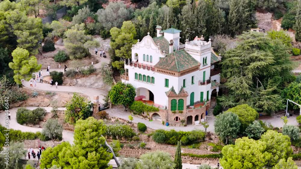 Aerial drone view of Park Guell. Antoni Gaudi architecture. A lot of greenery around, tourists, Barcelona, Spain Aerial drone view of Park Guell. Antoni Gaudi architecture. A lot of greenery around, tourists, Barcelona, Spain