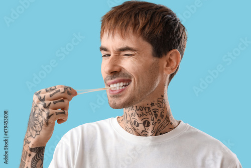 Young tattooed man chewing ...