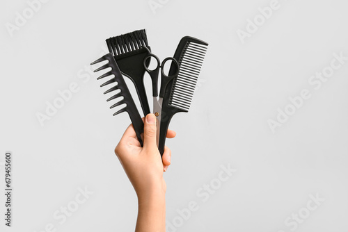 Female hand with hair supplies on white background.