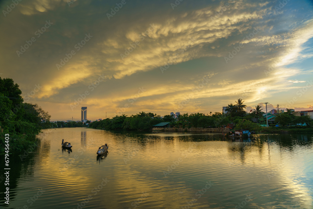 River view in Hue with traditional wooden boats and dramatic sunset sky in Hue city, Vietnam