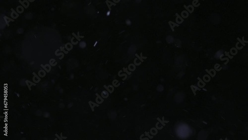 Snow flies on a dark background photo