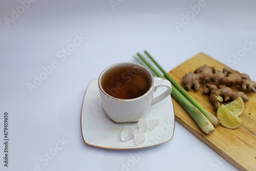 A cup of hot ginger tea with ginger root and lemongrass and rock sugar. the concept of herbal drinks for body warming and throat lozenges