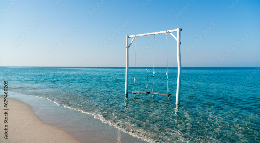 Empty swing on tropical beach with blue sky Empty swing on tropical beach with blue sky