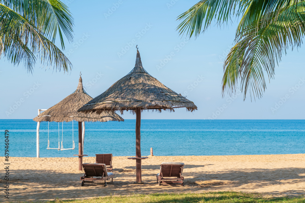 Fototapeta premium Tropical beach with palm tree and leaf umbrellas