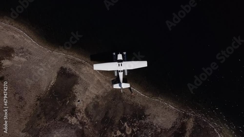 Aerial Top Down Dolly Out Above Seaplane Moored at Lake Shoreline photo