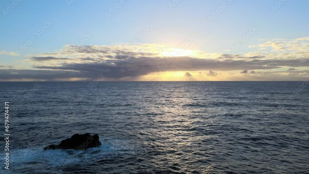 Gently gliding above, a drone observes the rhythmic dance of waves moving toward the shore as the sun sets over the picturesque landscape of Big Island, Hawaii Gently gliding above, a drone observes the rhythmic dance of waves moving toward the shore as the sun sets over the picturesque landscape of Big Island, Hawaii