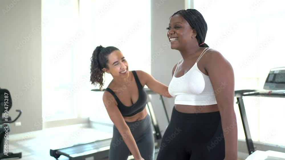 Fitness trainer or instructor training an African Black woman to stretch muscle before exercise. Fitness trainer or instructor training an African Black woman to stretch muscle before exercise.