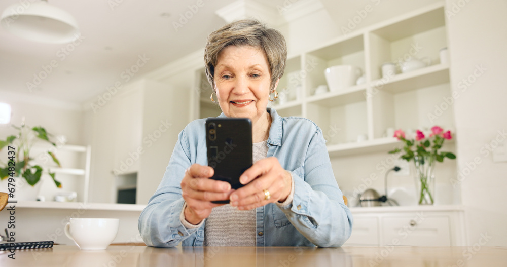 Happy senior woman, phone and social media in relax for communication or networking in kitchen at home. Mature female person smile on mobile smartphone for online chatting, texting or search at house Happy senior woman, phone and social media in relax for communication or networking in kitchen at home. Mature female person smile on mobile smartphone for online chatting, texting or search at house