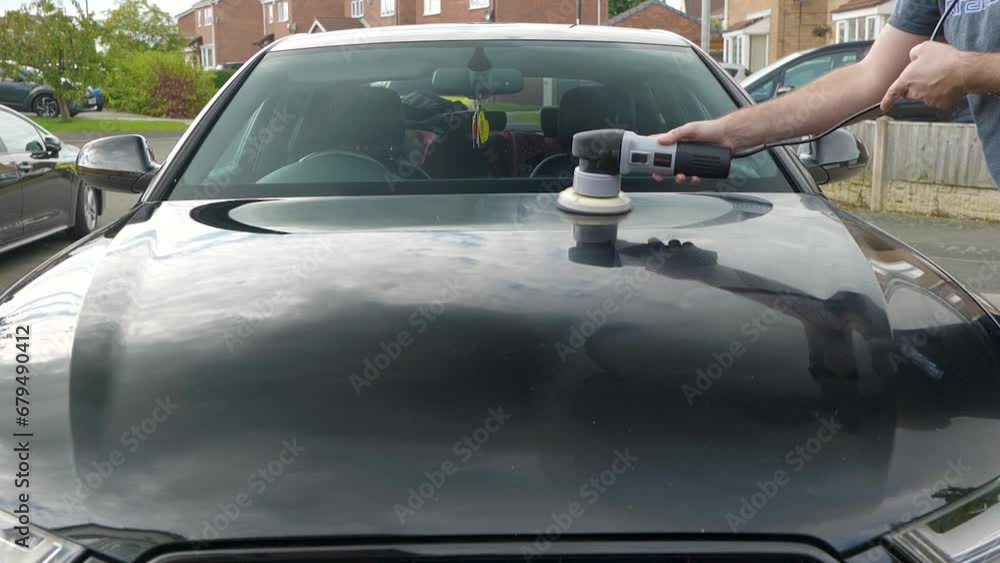Polishing a black car bonnet hood with a machine polisher Polishing a black car bonnet hood with a machine polisher