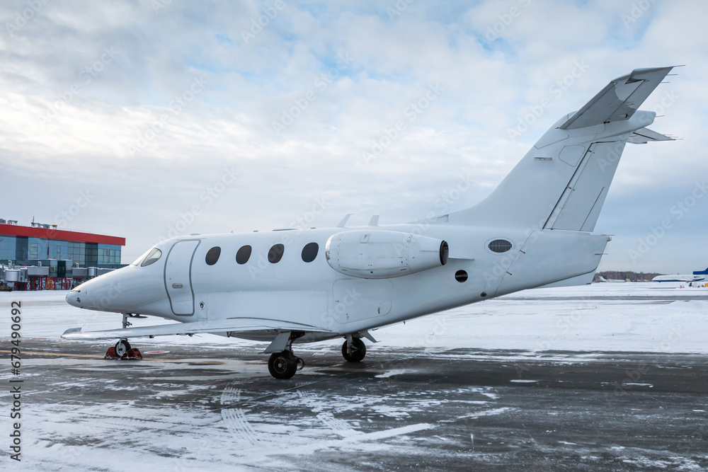 White executive airplane at winter airport apron White executive airplane at winter airport apron