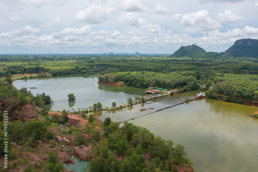 Aerial top view of a bridge with garden park with green mangrove forest trees, river, pond or lake. Nature landscape background, Thailand.