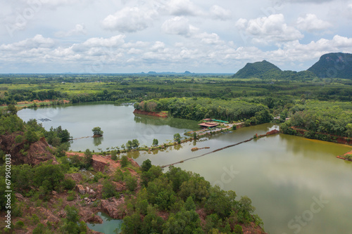 Aerial top view of a bridge with garden park with green mangrove forest trees, river, pond or lake. Nature landscape background, Thailand.