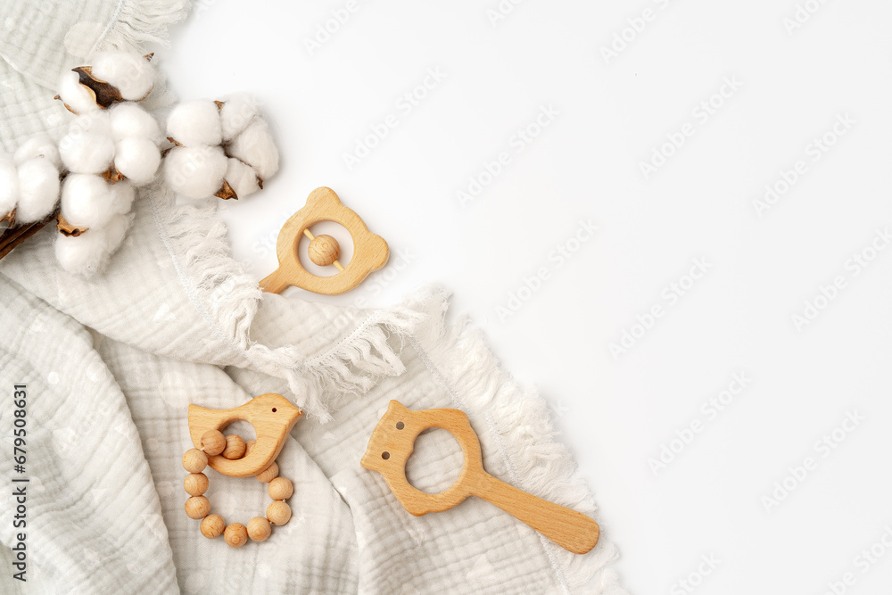 Muslin swaddle blanket with wooden toys on white background Muslin swaddle blanket with wooden toys on white background